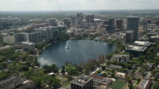 AX0034_086E - 5K aerial stock footage tilt from residential neighborhoods revealing Lake Eoloa and Downtown Orlando, Florida