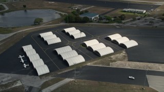 AX0034_116 - 5K aerial stock footage of flying over airplane hangers, Orlando Executive Airport, Florida