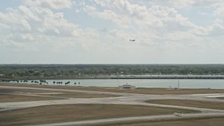 AX0034_117 - 5K aerial stock footage of tracking a plane taking off from an airport, Orlando Executive Airport