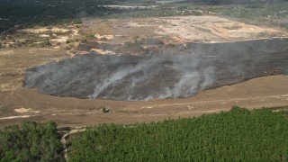 5K aerial stock footage of approaching a burn area and flames at a farm field, Winter Garden, Florida Aerial Stock Footage | AX0035_095