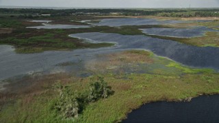 5K aerial stock footage fly over open water and patches of grassy land toward waterfront homes, Florida Aerial Stock Footage | AX0035_103E