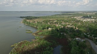 5K aerial stock footage tilt from shore to reveal and approach homes by Lake Apopka, Florida Aerial Stock Footage | AX0035_112E