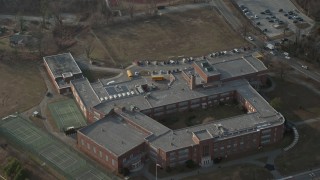 5K aerial stock footage tilt to bird's eye view of school busses at Great Neck North Middle School, Long Island, New York, winter Aerial Stock Footage | AX0065_0026