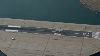 5K aerial stock footage of tracking a commercial jet landing on the runway at LaGuardia Airport, Queens, New York City, winter Aerial Stock Footage | AX0065_0036