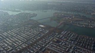 AX0065_0040E - 5K aerial stock footage tilt from a bird's eye view of urban neighborhoods to reveal bridges spanning the East River in Queens, New York City, winter