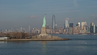 5K aerial stock footage flyby Statue of Liberty to focus on Freedom Tower and Lower Manhattan skyline in the distance, New York City, winter Aerial Stock Footage | AX0065_0082