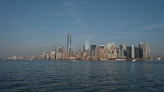 AX0065_0084E - 5K aerial stock footage tilt from New York Harbor to reveal and approach the Lower Manhattan skyline, New York City, winter