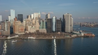 AX0065_0097E - 5K aerial stock footage of flying by Battery Park and the Lower Manhattan skyline, New York City, winter