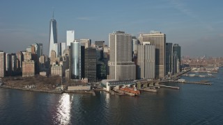 5K aerial stock footage flyby Battery Park, Lower Manhattan skyline, and the Staten Island Ferry Terminal, New York City, winter Aerial Stock Footage | AX0065_0099E