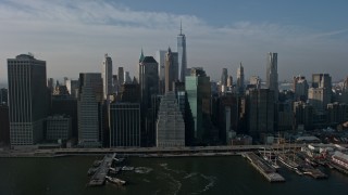 5K aerial stock footage of Lower Manhattan skyscrapers and East River piers, Freedom Tower in the distance, New York City, winter Aerial Stock Footage | AX0065_0103