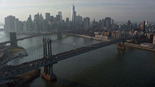 5K aerial stock footage flyby the Manhattan Bridge with a view of the Lower Manhattan skyline and the Brooklyn Bridge, New York City, winter Aerial Stock Footage | AX0065_0145