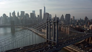 AX0065_0146E - 5K aerial stock footage of Manhattan Bridge with the Lower Manhattan skyline and the Brooklyn Bridge in the background, New York City, winter