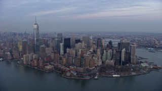 AX0065_0213E - 5K aerial stock footage of Battery Park and Lower Manhattan skyscrapers in New York City, winter, twilight