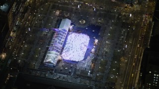 5K aerial stock footage orbit a skyscraper to reveal the ice skating rink at Bryant Park in Midtown Manhattan, New York City, winter, night Aerial Stock Footage | AX0065_0329E