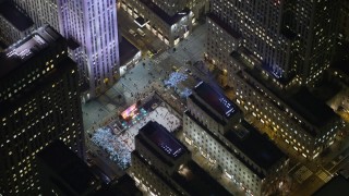 5K aerial stock footage orbit Rockefeller Center skyscraper to reveal the ice skating rink, Midtown Manhattan, New York City, winter, night Aerial Stock Footage | AX0065_0335E