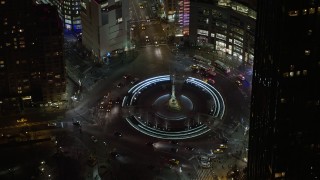 AX0065_0347E - 5K aerial stock footage of police vehicles and light traffic on Columbus Circle in Midtown Manhattan, New York City, winter, night