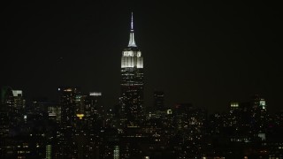 AX0065_0372 - 5K aerial stock footage of the Empire State Building skyscraper in Midtown Manhattan, New York City, winter, night