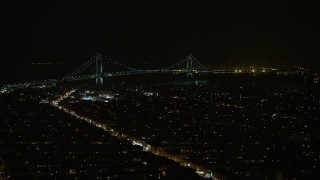 5K aerial stock footage of Verrazano-Narrows Bridge seen from Brooklyn neighborhoods in New York City, winter, night Aerial Stock Footage | AX0065_0396E