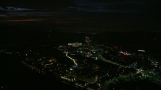 AX0156_004E - 7.6K aerial stock footage approaching Universal Studios Hollywood in Universal City at night in California