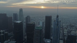 7.6K aerial stock footage flying over skyscrapers in Downtown Los Angeles, California to approach the rising sun and Boyle Heights Aerial Stock Footage | AX0156_112E