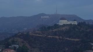 AX0156_118 - 7.6K aerial stock footage of a view of the Hollywood Sign seen while passing Griffith Observatory at sunrise in Los Angeles, California