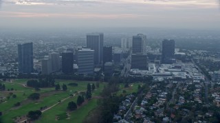 7.6K aerial stock footage flying over golf course along office buildings and skyscrapers, sunrise, Century City, California Aerial Stock Footage | AX0156_132