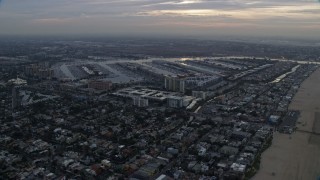 AX0156_172E - 7.6K aerial stock footage flying over Venice neighborhoods to approach and flyby Marina Del Rey harbor at sunrise, California