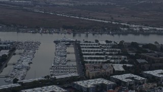 7.6K aerial stock footage of a mega yacht docked in the harbor near waterfront apartment buildings at sunrise in Marina Del Rey, California  Aerial Stock Footage | AX0156_174