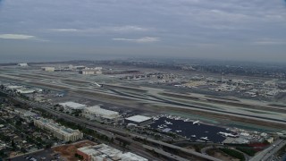 7.6K aerial stock footage approaching LAX in the morning as a FedEx airplane starts down the runway, California Aerial Stock Footage | AX0156_192E