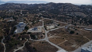 AX0157_049E - 7.6K aerial stock footage orbiting and flying over buildings at the Rocketdyne aerospace testing facility in Brandeis, California