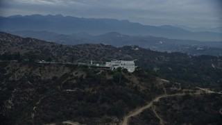 AX0158_011E - 7.6K aerial stock footage orbiting Griffith Observatory from behind to reveal skyline and city sprawl, twilight, Los Angeles, California