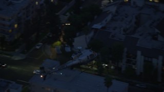 AX0158_066 - 7.6K aerial stock footage tracking LAPD helicopter at twilight over Los Angeles, California