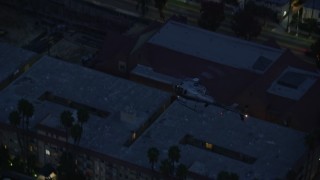 7.6K aerial stock footage tracking an LAPD helicopter flying over Hollywood, California at twilight Aerial Stock Footage | AX0158_067E