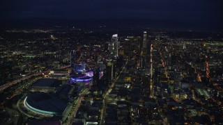 AX0158_083E - 7.6K aerial stock footage of heavy nighttime traffic on the 110 by skyscrapers, Staples Center, and the convention center, Downtown Los Angeles, California