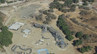 7.6K aerial stock footage orbiting away form old Wipe Out set and a dinosaur structure at Sable Ranch, Santa Clarita, California Aerial Stock Footage | AX0159_054