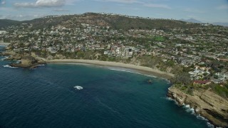 AX0159_203 - 7.6K aerial stock footage flying by homes beside Three Arch Bay Beach in Laguna Beach, California