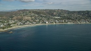 7.6K aerial stock footage flying away from beach and over coastal community, Laguna Beach, California Aerial Stock Footage | AX0159_212E