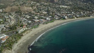 AX0159_220E - 7.6K aerial stock footage orbiting business and houses near the beach, Laguna Beach, California