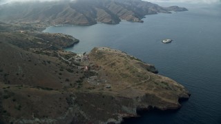 7.6K aerial stock footage flying by coastal cliffs to approach the marine science center in Two Harbors, Santa Catalina Island, California Aerial Stock Footage | AX0160_005E