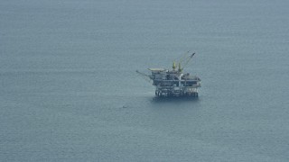 AX0160_034 - 7.6K aerial stock footage flying by an oceanic oil rig off the coast of Southern California