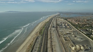 7.6K aerial stock footage of homes around an industrial area next to the beach and Hwy 1, Huntington Beach, California Aerial Stock Footage | AX0160_044E