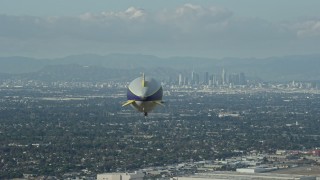 7.6K aerial stock footage of the Goodyear Blimp flying toward Downtown Los Angeles skyline from Long Beach Airport, California Aerial Stock Footage | AX0160_062E