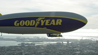 AX0160_064E - 7.6K aerial stock footage of the Goodyear Blimp flying over Long Beach, California