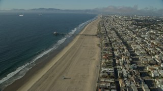 AX0161_040E - 7.6K aerial stock footage of Manhattan Beach Pier seen while flying over beachside neighborhoods in Manhattan Beach, California