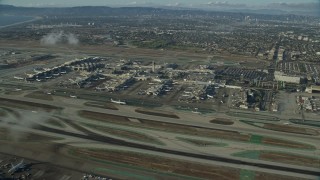 7.6K aerial stock footage approaching the airport as airlines taxi on the runways, LAX, California Aerial Stock Footage | AX0161_045E