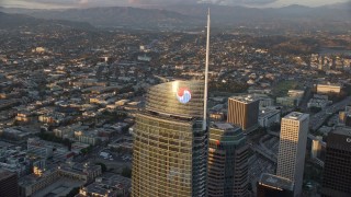 AX0162_080 - 7.6K aerial stock footage orbiting the top of Wilshire Grand Center at sunset in Downtown Los Angeles, California