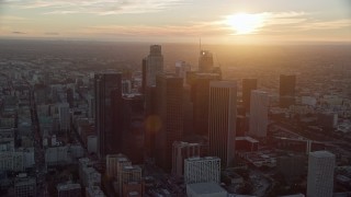 AX0162_085E - 7.6K aerial stock footage of a reverse view of the tall towers of downtown at sunset in Downtown Los Angeles, California