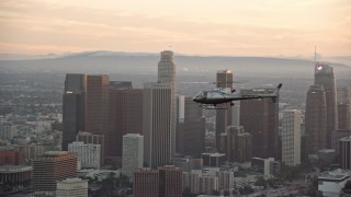 7.6K aerial stock footage tracking an LAPD helicopter flying by the skyline of Downtown Los Angeles, California at twilight Aerial Stock Footage | AX0162_092E