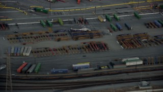 AX0162_097 - 7.6K aerial stock footage tracking an LAPD helicopter flying over shipping containers in Downtown Los Angeles, California at twilight