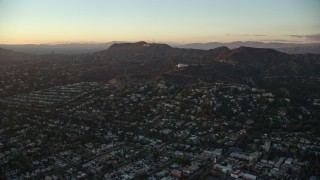 AX0162_098 - 7.6K aerial stock footage flying over Los Feliz to approach the Hollywood Sign and Griffith Observatory in Los Angeles, California at twilight